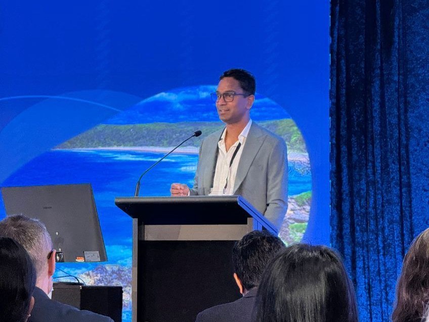 A/Prof Viraj Kariyawasam speaking at a lectern during the 2026 GESQ Noosa Update